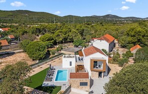 A modern villa with a swimming pool, surrounded by lush greenery and hills. - Gorgeous home in Dubrava Kod Sibenika with sauna (Dubrava Kod Sibenika)
