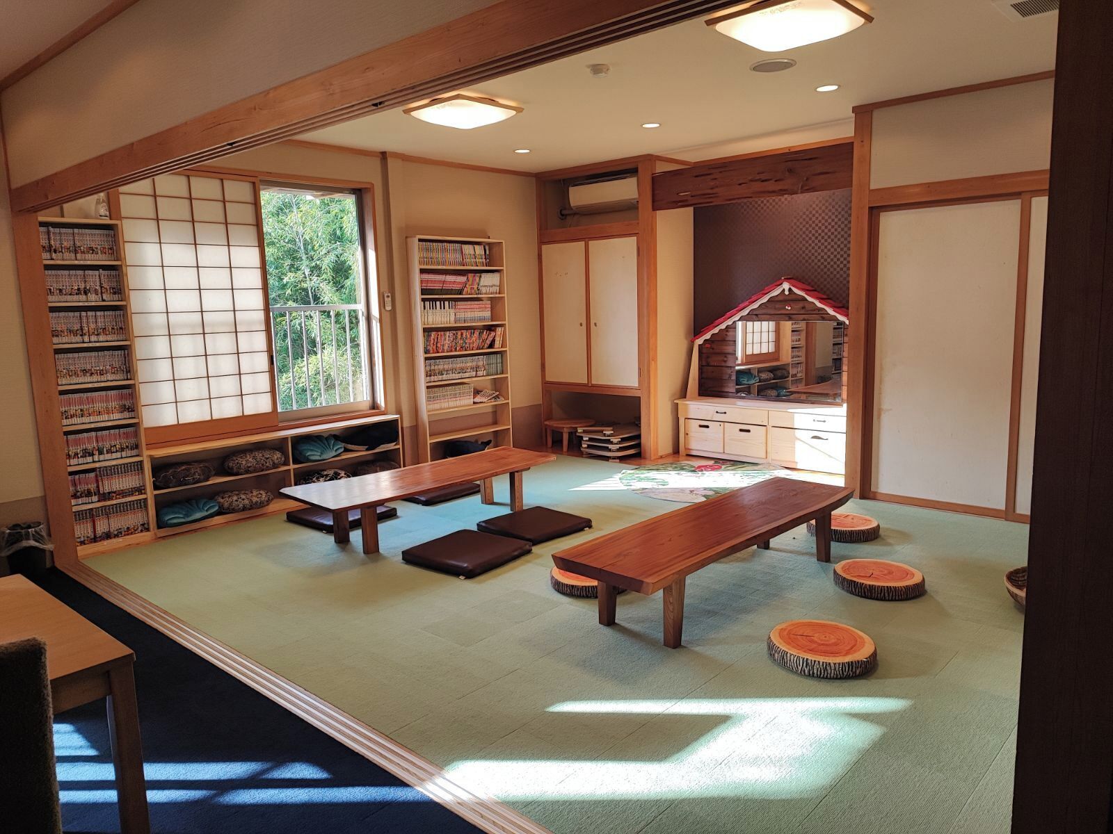 A traditional Japanese room with tatami flooring, a low wooden table, and a bookshelf.