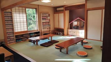 A traditional Japanese room with tatami flooring, a low wooden table, and a bookshelf.