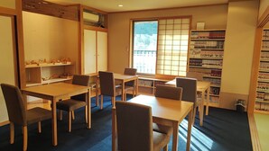 Quarto com decoração tradicional japonesa, incluindo tatames, móveis de madeira e uma estante repleta de livros.