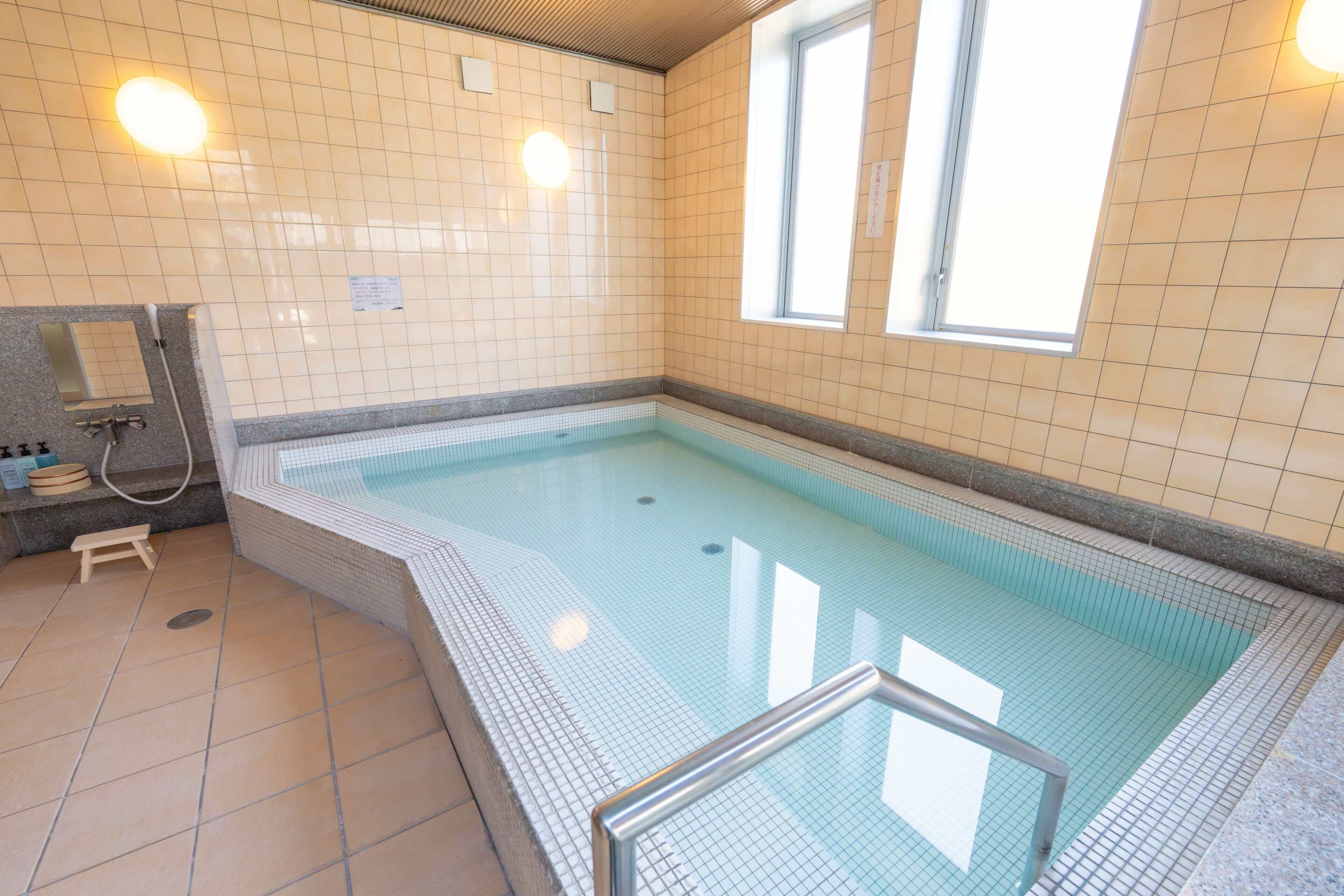 A swimming pool with tiled walls and a window.