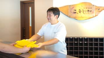 A person handing over a yellow item to another person at a counter with a wooden plaque on the wall.