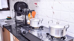 Eine Küche mit zwei Gasherden, einem Geschirrgestell und einem Wasserkocher.
