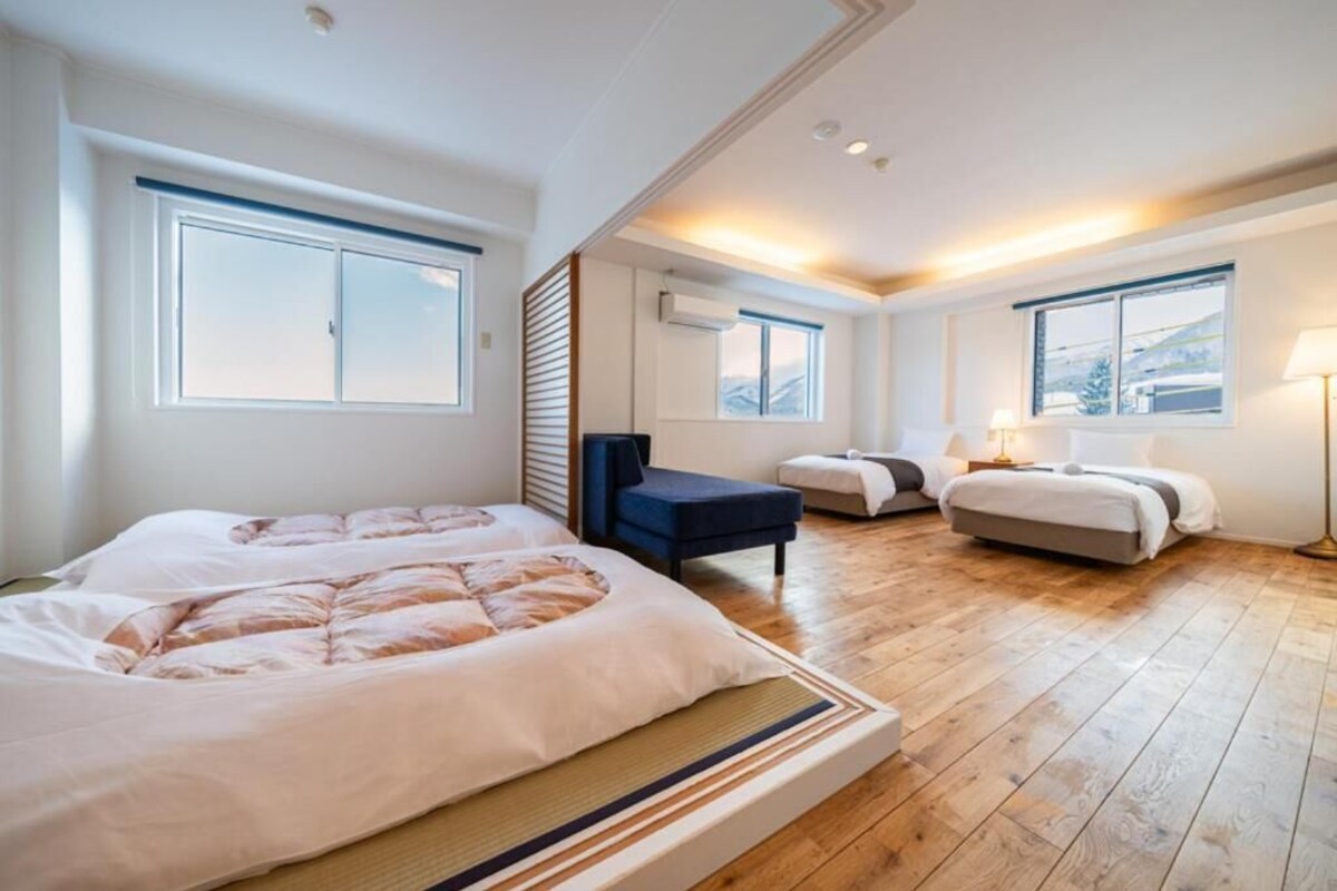 Ett hotellrum med två sängar, en soffa, ett skrivbord och en lampa.