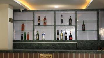 A reception area with a marble counter and shelves displaying various bottles.