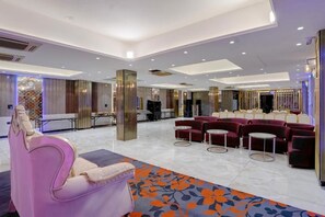 A spacious lobby with a seating area, a reception desk, and a patterned carpet. - OnlyStay Anandam Residency (Greater Noida)