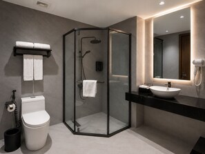 A modern bathroom with a glass-enclosed shower, a toilet, a sink with a vanity, and a mirror with a built-in hair dryer. - Chu Gia Hotel Mong Cai (Mong Cai)