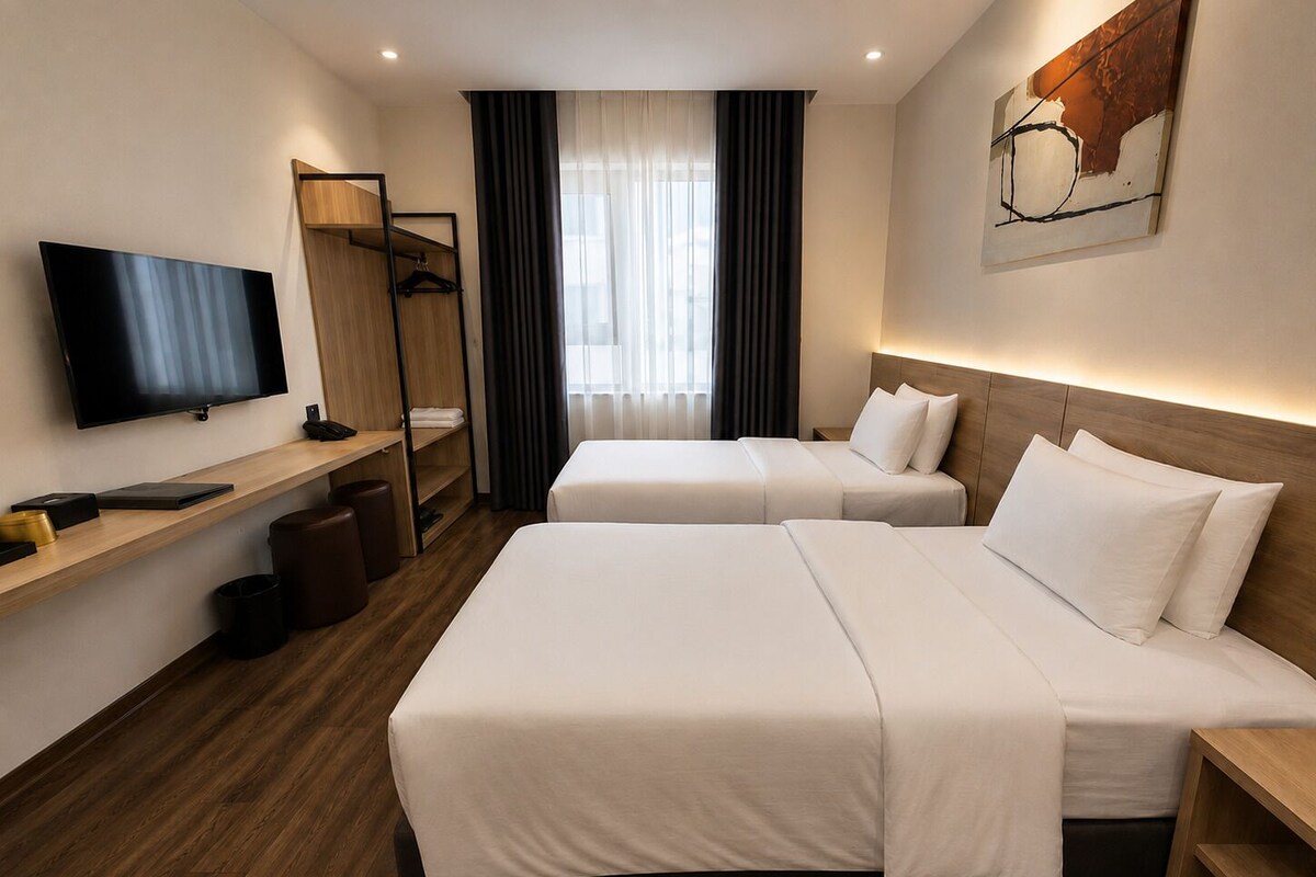 A hotel room with two beds, a TV, a wooden shelf, and a painting on the wall.