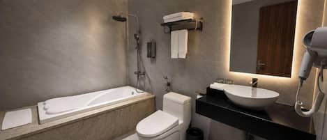 A modern bathroom with a bathtub, toilet, and sink.
