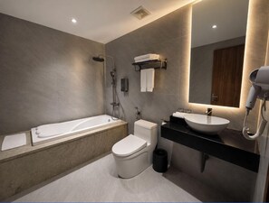 A modern bathroom with a bathtub, toilet, and sink. - Chu Gia Hotel Mong Cai (Mong Cai 2)