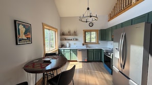 A kitchen with a refrigerator, stove, and wooden cabinets.