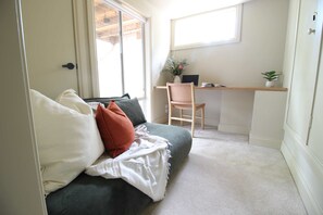 A cozy room with a bed, a desk, and a chair.