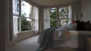 A bedroom with a large bed, multiple windows, and a view of trees. - Casa Vista, Dandenong Ranges forest retreat (Kalorama)