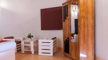 Una habitación con una cama, una mesita de noche con una planta, un armario y un espejo.