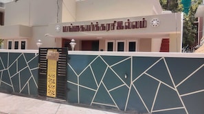 A building with a geometric wall design and a sign indicating rooms are available.