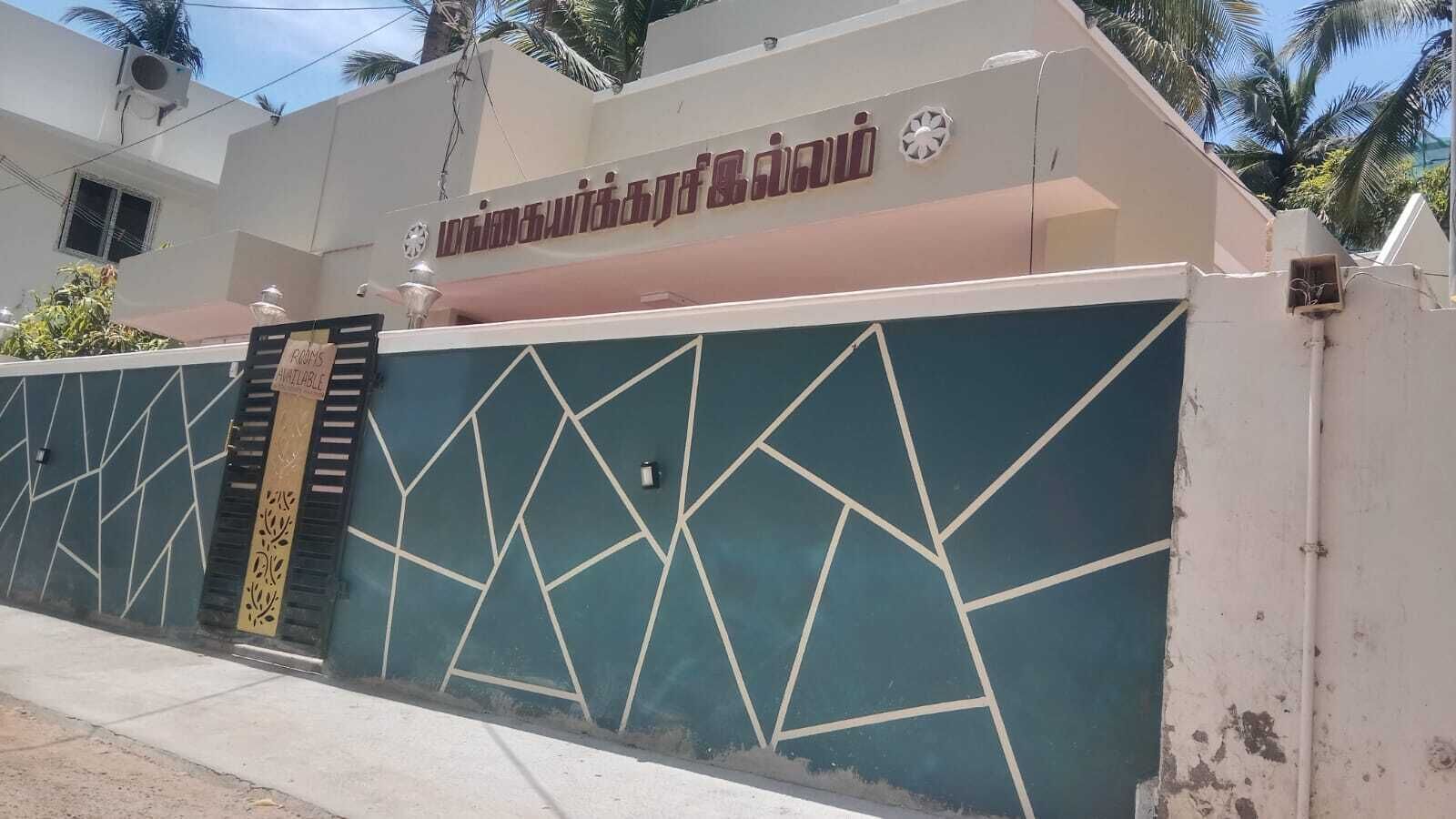 A building with a geometric wall design, a sign indicating 'Available,' and a staircase leading to an entrance.