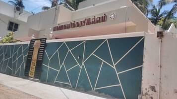 A building with a geometric wall design, a sign indicating 'Available,' and a staircase leading to an entrance.