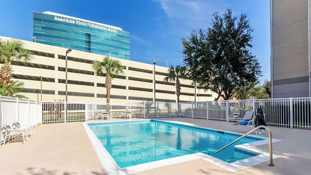 Ein Pool mit Blick auf eine mehrstöckige Parkgarage und ein Gebäude im Hintergrund.