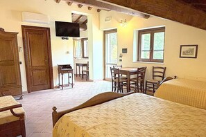 A room with a bed, a desk, and a television. - Casa Fronda A: A graceful apartment that is part of an ancient country house situated at a short distance from the shores of Lake Piediluco, with Free WI-FI. (Terni)