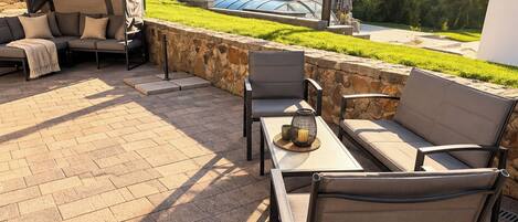 An outdoor patio with a sofa, chairs, and a table.