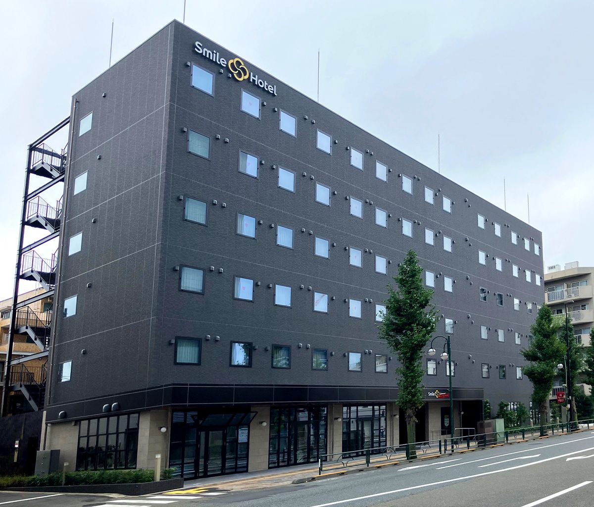 A multi-story hotel with a modern design, featuring a prominent logo at the top.