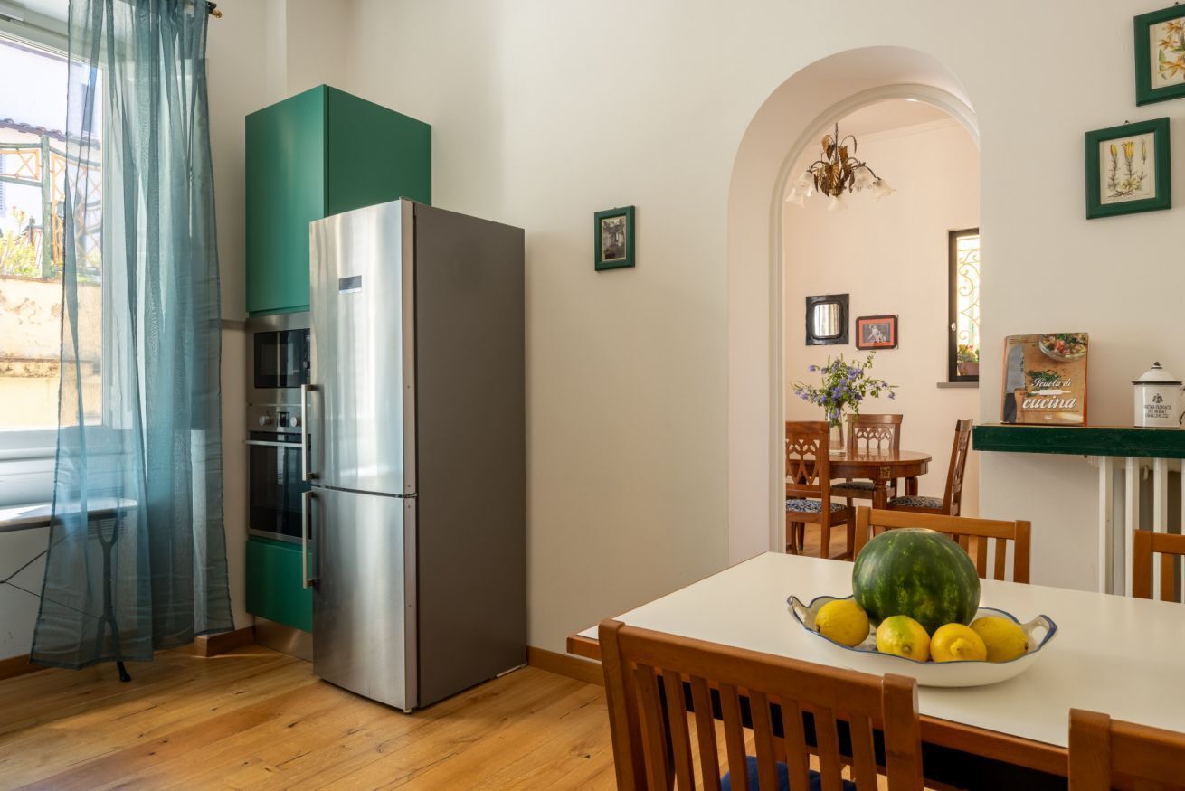 Une cuisine équipée d’un réfrigérateur, d’un four et d’une table à manger avec des chaises.