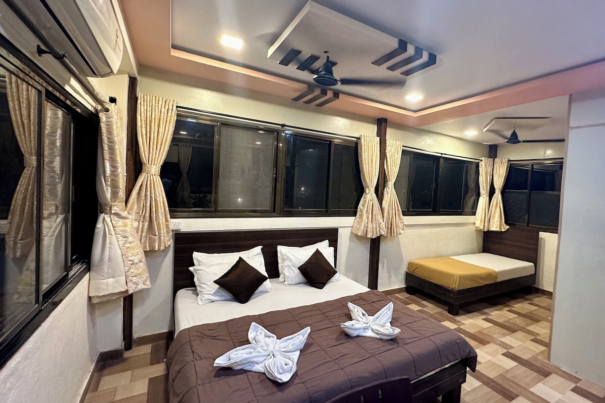 A hotel room with a bed, a sofa, a ceiling fan, and curtains.