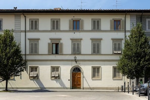 A two-story building with a central entrance, multiple windows with shutters, and a paved ground. - The Nerli Edit by Maison Florence (Florence)