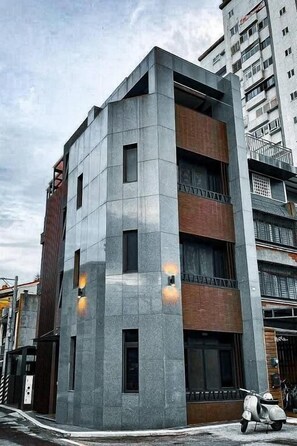 A multi-story building with a modern architectural design, featuring a combination of concrete and brick materials. - leesu (Hualien City)