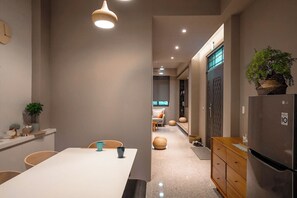 A modern kitchen with a central island, a refrigerator, and a dining area with chairs and a table. - leesu (Hualien City)