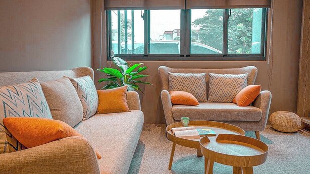 A living room with two sofas, a coffee table, and a large window with a view of the outside. - leesu (Hualien County)