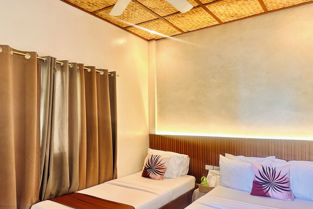 A hotel room with two beds, a wooden headboard, and a ceiling with a woven pattern.