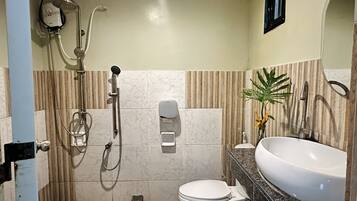 Een badkamer met toilet, wastafel, douche en handdroger.