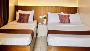 Quarto de hotel com duas camas, cabeceira de madeira, ventoinha no teto e detalhe decorativo trançado no teto.