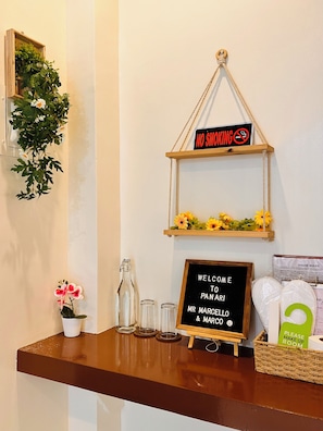 A reception area with a welcome sign, a no smoking sign, and a small plant.