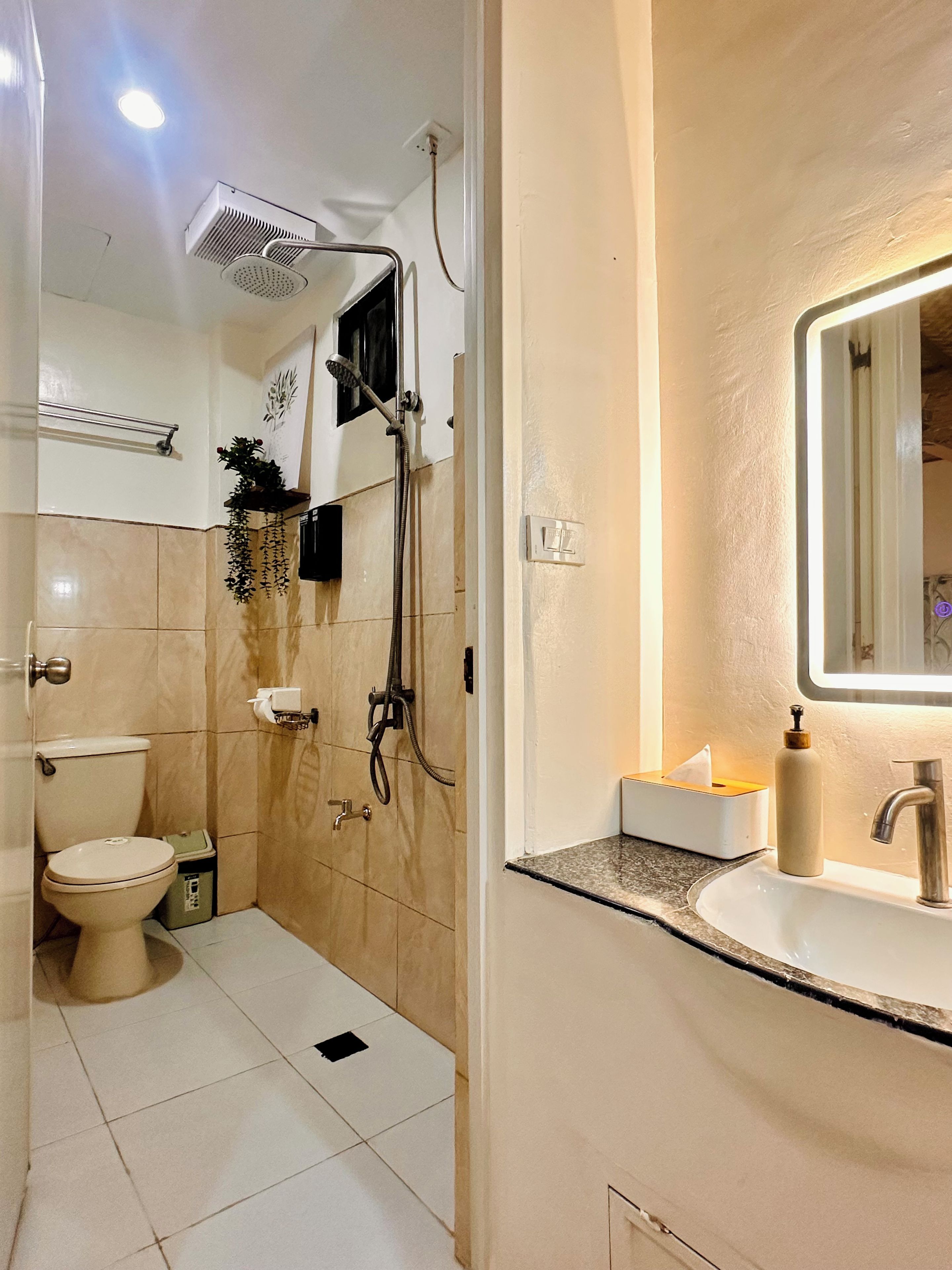 Ein Badezimmer mit Dusche, Toilette, Waschbecken und Spiegel.