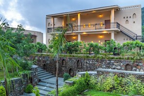 Un edificio de varios pisos con una escalera de piedra que lleva a un balcón.
