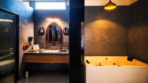 A modern bathroom with a large mirror, a sink, and a bathtub. - The Talhati (Kumbhalgarh)