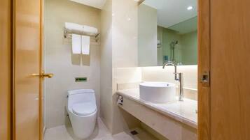 A bathroom with a toilet, a sink, and a mirror.
