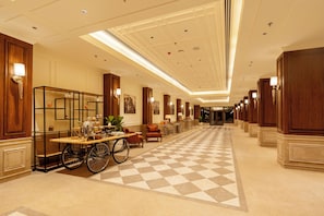 A hotel lobby with a checkered floor, a coffee cart, and a wheelchair. - Aurika Naldehra Shimla (Suni)