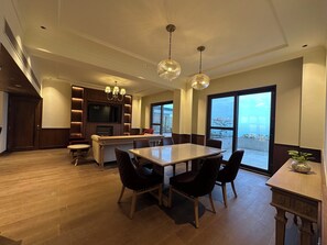 Een moderne keuken met een eethoek, grote ramen en een open haard.