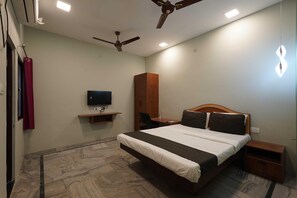 A bedroom with a bed, a television, a wardrobe, a desk, and a ceiling fan. - Villa Tian by Palette Homes (Chennai)