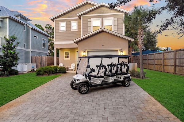 Golden-hour curb appeal with a six-seat golf cart ready for easy coastal adventures.