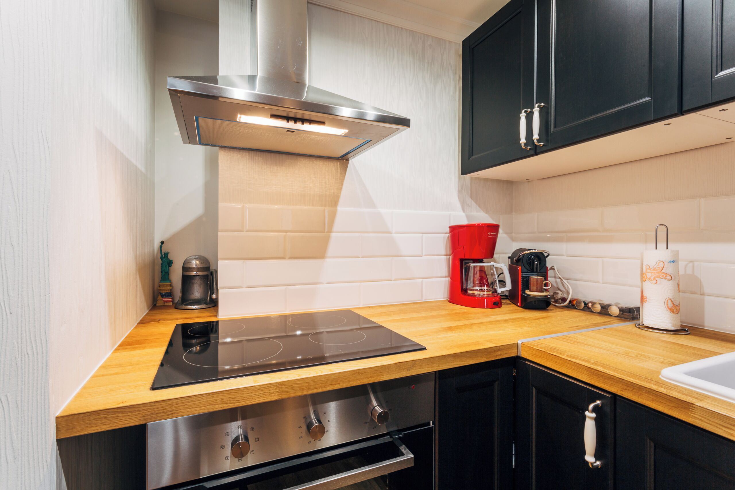 Een moderne keuken met een ingebouwde kookplaat, oven en een koffieapparaat.