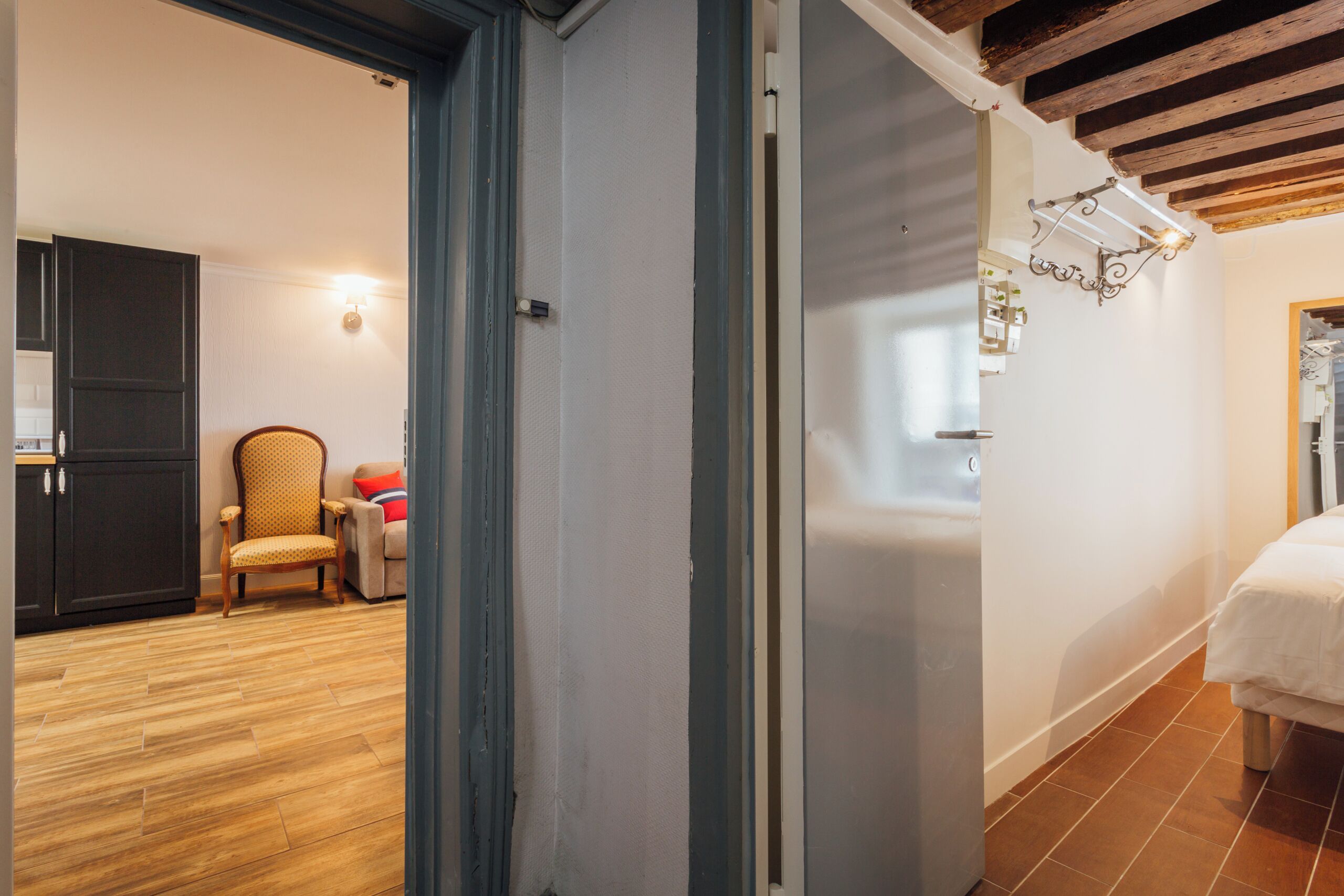 Une pièce avec un plancher en bois, un lit, une chaise et une armoire.