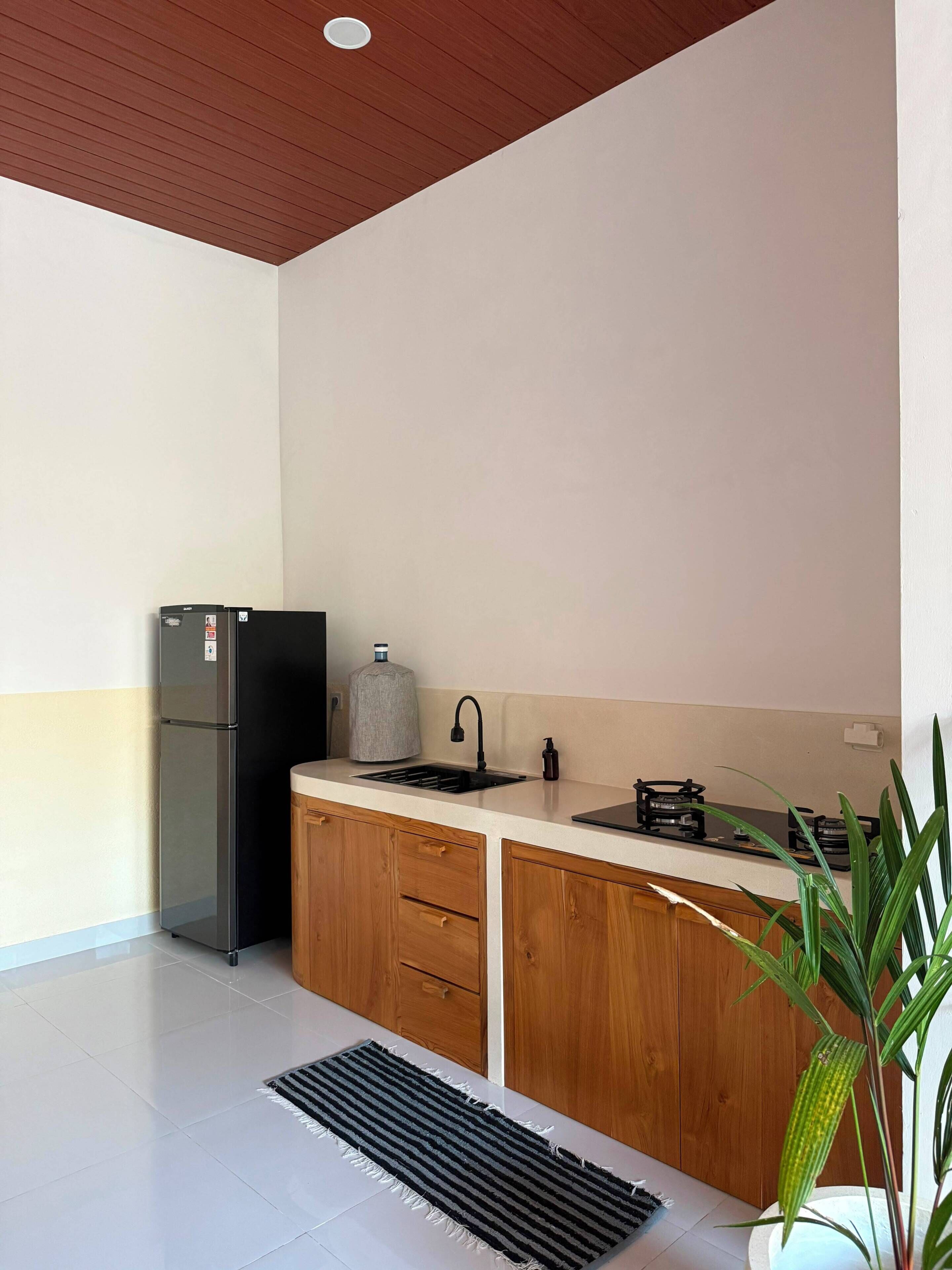 Una cocina moderna con refrigerador integrado, un lavamanos y una estufa.