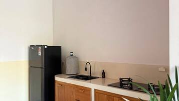 Una cocina moderna con refrigerador integrado, un lavamanos y una estufa.