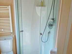 A bathroom with a glass-enclosed shower, a toilet, and a towel rack. - 2 bedroom accommodation in Newquay (Newquay)
