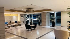 Un vestíbul modern amb zona de seients, taulell de recepció i una finestra gran.