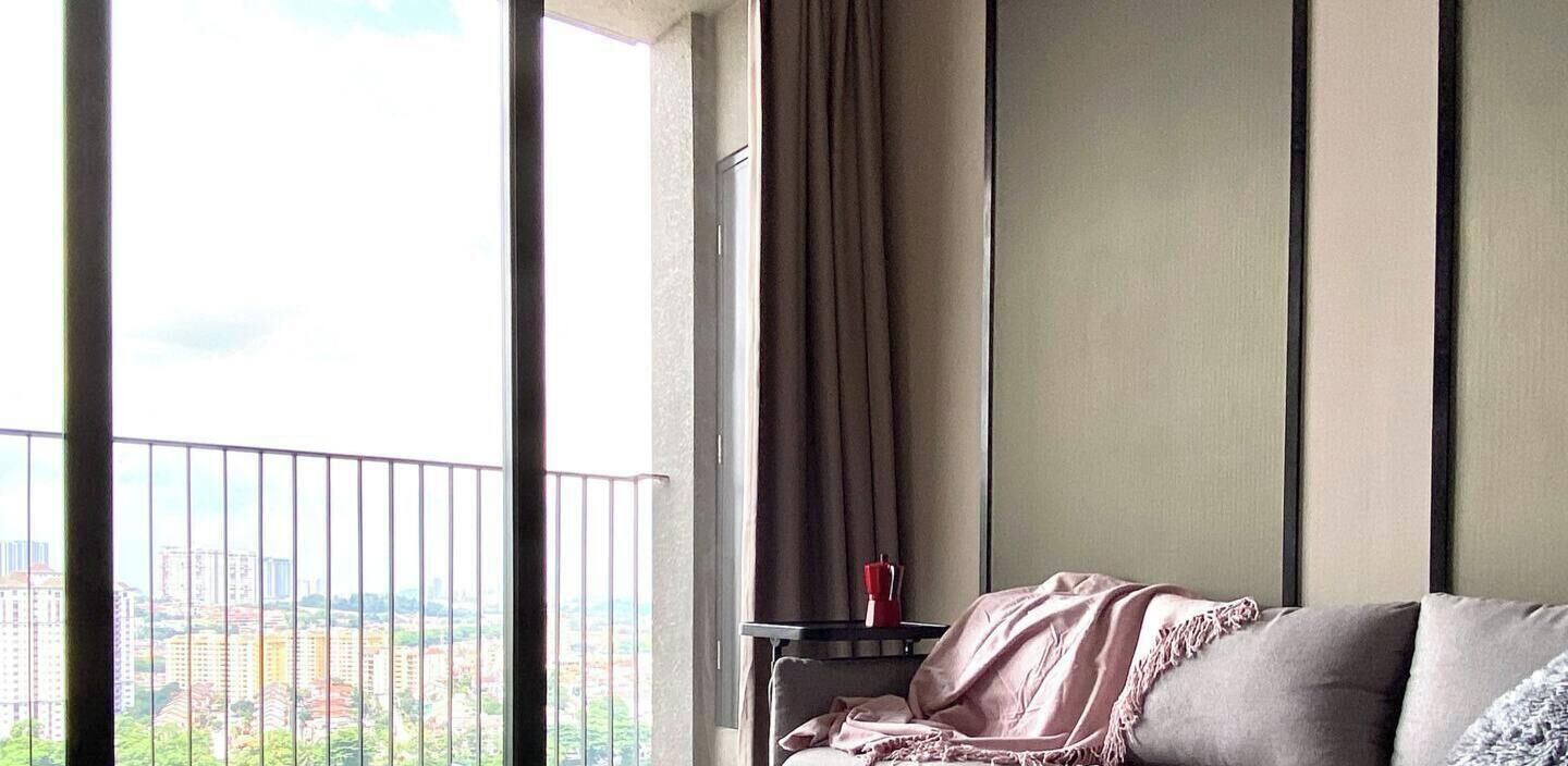 Una habitación con balcón, cama, mesita de noche y vistas a la ciudad.